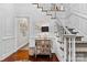 Elegant foyer featuring hardwood floors, white staircase, mirrored chest of drawers, and decorative accents at 3717 Bounty Ct, Matthews, NC 28104