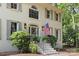 Close up of the home's entrance with an American flag, white stairs and iron railing and mature landscaping at 3717 Bounty Ct, Matthews, NC 28104