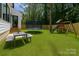Lush backyard featuring a trampoline, swing set, patio seating and a private fence, perfect for outdoor activities at 3953 Plainview Rd, Charlotte, NC 28208