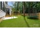 Spacious backyard featuring a grassy lawn, playground swing, and trampoline for outdoor enjoyment at 3953 Plainview Rd, Charlotte, NC 28208