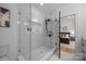 Modern bathroom with a frameless glass shower, matte black hardware, and marble-look tile surround at 3953 Plainview Rd, Charlotte, NC 28208