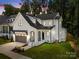 New construction home with a modern farmhouse style, gray garage, and a beautiful lawn at dusk at 3953 Plainview Rd, Charlotte, NC 28208
