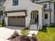 Modern farmhouse style home with gray garage, with landscaping around the walkway to the front door at 3953 Plainview Rd, Charlotte, NC 28208