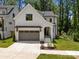 Modern farmhouse style home with gray garage, with landscaping around the walkway to the front door at 3953 Plainview Rd, Charlotte, NC 28208