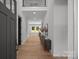 Bright foyer with hardwood floors and view into a living room with large windows and an iron-railed loft space at 3953 Plainview Rd, Charlotte, NC 28208