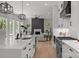 Spacious kitchen with white cabinets, black hardware, stainless appliances, and seamless open floorplan to living area at 3953 Plainview Rd, Charlotte, NC 28208