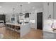 Open-concept kitchen features a large center island, white cabinets, modern lighting, and an adjacent living area at 3953 Plainview Rd, Charlotte, NC 28208