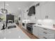 Modern kitchen featuring stainless steel appliances, white cabinets, quartz countertops, and adjacent open living area at 3953 Plainview Rd, Charlotte, NC 28208