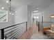 Bright loft area with modern light fixture, comfortable seating, and black iron railings at 3953 Plainview Rd, Charlotte, NC 28208