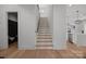 Stairway leading to the upper level, adjacent to kitchen, featuring light wood treads and black iron railing at 3953 Plainview Rd, Charlotte, NC 28208