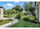 Landscaped backyard with lush lawn, mature trees, and a charming walkway leading to a relaxing outdoor space at 402 Walnut St, China Grove, NC 28023