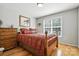 Comfortable bedroom with wood floors, a window with blinds, and a rustic dresser at 402 Walnut St, China Grove, NC 28023