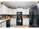 Charming kitchen featuring white cabinets, modern black appliances, and decorative accents at 402 Walnut St, China Grove, NC 28023
