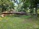 Unique circular home featuring wood siding, a brown roof, and natural landscaping, nestled among mature trees at 404 Long Shoals Rd, Bessemer City, NC 28016