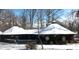 Winter view of an architectural home featuring a unique roof and stone detailing, covered in a blanket of snow at 404 Long Shoals Rd, Bessemer City, NC 28016