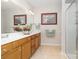 Well-lit bathroom with double vanity, framed mirrors, and a walk-in shower at 4079 Murray St, Fort Mill, SC 29707