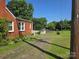 View of a spacious backyard with mature trees and an outbuilding at 412 Ridge St, Stanley, NC 28164