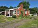 Lovely brick home featuring a covered porch and lush green lawn at 412 Ridge St, Stanley, NC 28164
