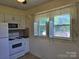 Bright kitchen featuring white appliances, cabinets, and a window providing natural light at 412 Ridge St, Stanley, NC 28164