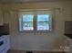 Cozy kitchen featuring white cabinets, a double window with lace curtains, and tile backsplash at 412 Ridge St, Stanley, NC 28164