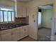 Kitchen sink with white cabinets and tile flooring; a view into another room at 412 Ridge St, Stanley, NC 28164