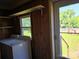 Laundry room with view of the yard with mature trees through a glass paneled door and window at 412 Ridge St, Stanley, NC 28164