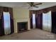 Bright living room featuring a fireplace, carpet and large windows with decorative curtains at 412 Ridge St, Stanley, NC 28164
