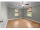 Bedroom featuring hardwood floors, neutral walls, a ceiling fan, and two windows with views of the outdoors at 435 Stirewalt Rd, China Grove, NC 28023