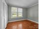 A bedroom with hardwood floors, neutral-toned walls, large windows offering a view of the outdoors, and a spacious closet at 435 Stirewalt Rd, China Grove, NC 28023