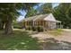 Charming single-story home featuring a welcoming front porch, mature trees, and stylish shutters at 435 Stirewalt Rd, China Grove, NC 28023