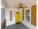 Cozy front porch with wood-look ceiling fan, shutters, and a cheerful yellow door at 435 Stirewalt Rd, China Grove, NC 28023