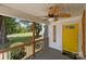 Cozy front porch with wood railing, featuring a decorative ceiling fan and yellow front door at 435 Stirewalt Rd, China Grove, NC 28023