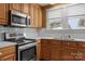 Close-up of kitchen with stainless steel oven, microwave, and wooden cabinetry at 435 Stirewalt Rd, China Grove, NC 28023