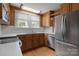 Kitchen with wooden cabinetry, stainless steel refrigerator and view to backyard at 435 Stirewalt Rd, China Grove, NC 28023