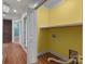 A laundry room with yellow walls and a washer hookup. The room has hardwood floors and a shelf for storage at 435 Stirewalt Rd, China Grove, NC 28023