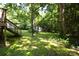 Lush backyard features a deck with stairs and a vintage outbuilding nestled among mature trees at 438 Faith Sw Dr, Concord, NC 28027