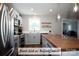 Stylish kitchen featuring stainless steel appliances, floating wood shelves, and a large sink at 4429 Dawnwood Dr, Gastonia, NC 28056