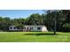 Single story home with front porch nestled amongst mature trees on a large lot at 4688 Taxahaw Rd, Lancaster, SC 29720