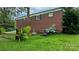 A brick home features a backyard with landscaping, including flowers and manicured plants for curb appeal at 5083 Fleetwood Dr, Hickory, NC 28602