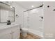 Bathroom featuring a shower and single sink with matte black fixtures and wood-look flooring at 517 Dutch Ave, Mount Holly, NC 28120