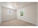 Bright bedroom with neutral carpet and two windows offering ample natural light at 517 Dutch Ave, Mount Holly, NC 28120