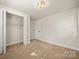 Carpeted bedroom view featuring a closet and a single door to another room at 517 Dutch Ave, Mount Holly, NC 28120