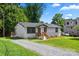 Landscaped ranch-style house featuring a gravel driveway, a new construction property, and mature shade trees at 517 Dutch Ave, Mount Holly, NC 28120