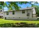 View of home with vinyl siding, black window trim, brick foundation, and small deck at 517 Dutch Ave, Mount Holly, NC 28120