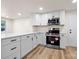 Bright kitchen with white cabinets, stainless steel appliances, white countertops, and wood-look floors at 517 Dutch Ave, Mount Holly, NC 28120
