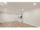 Open concept space with wood-look floors, recessed lighting, and view into the kitchen with white cabinets at 517 Dutch Ave, Mount Holly, NC 28120