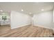 Open concept with wood-look floors, recessed lights, and view into the kitchen with white cabinets and sink at 517 Dutch Ave, Mount Holly, NC 28120