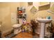 Modest bathroom features pedestal sink, toilet, and shelving unit for toiletries and cleaning supplies at 517 Fieldcrest Dr, Chester, SC 29706