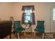Cozy living room displays two teal chairs, a small table, and a window with charming gray curtains at 517 Fieldcrest Dr, Chester, SC 29706