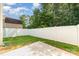 Grassy backyard featuring a privacy fence, a concrete pad, and mature trees, offering a private outdoor space at 523 Smokehouse Ln, Albemarle, NC 28001